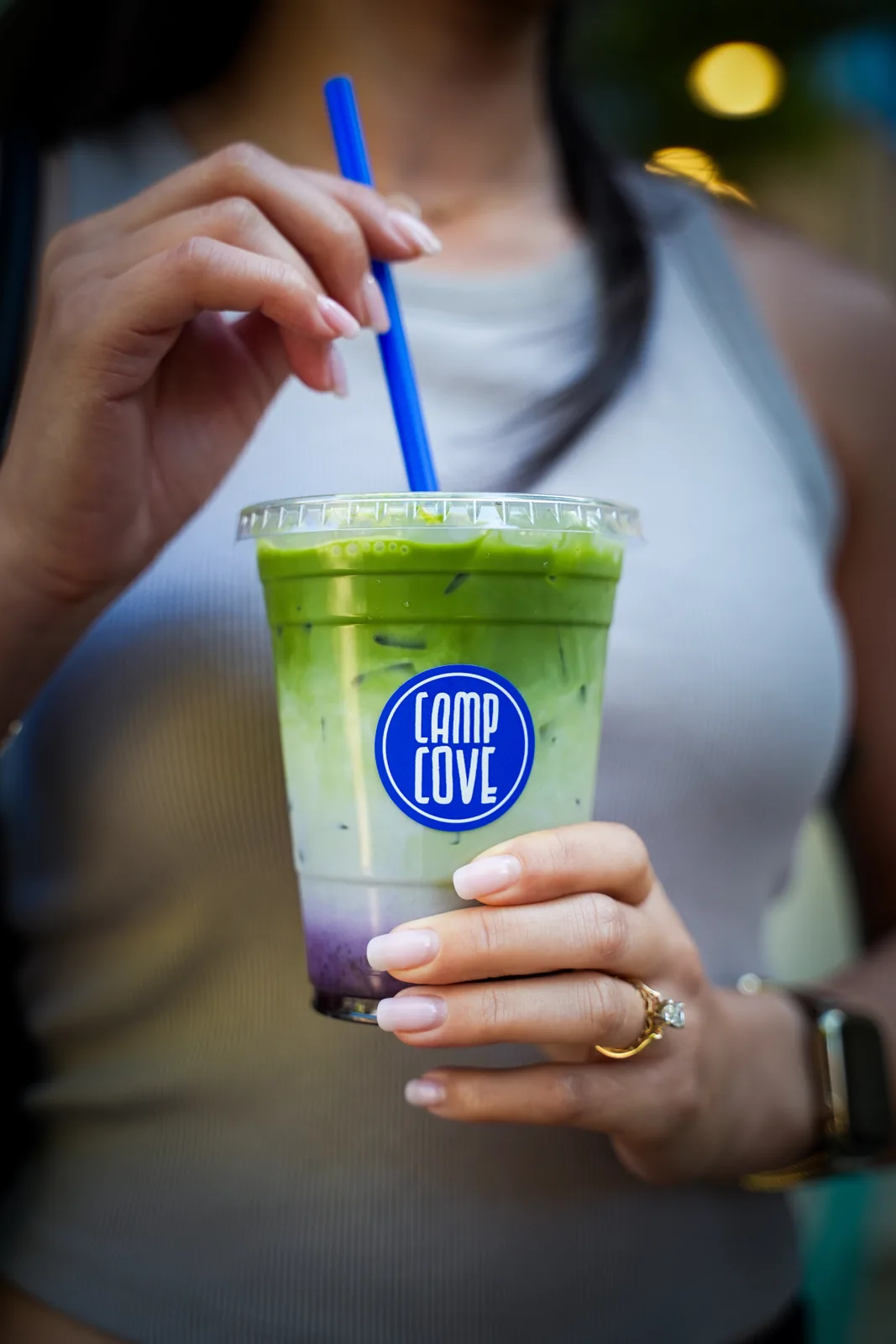 A guest holding a Camp Cove iced matcha